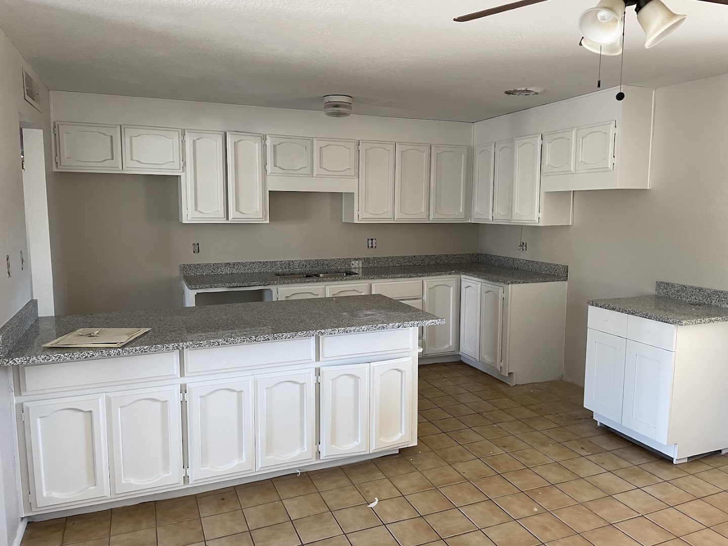 Freshly painted white kitchen cabinets with granite countertops